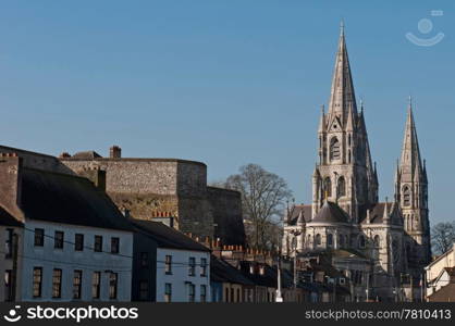 Cork cityscape featuring at the left Elizabeth Fort and on the right Saint Fin Barre&rsquo;s Cathedral, Ireland (blue sky background)