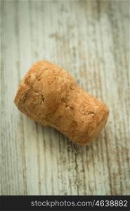 Cork from a champagne bottle on a wooden background worn