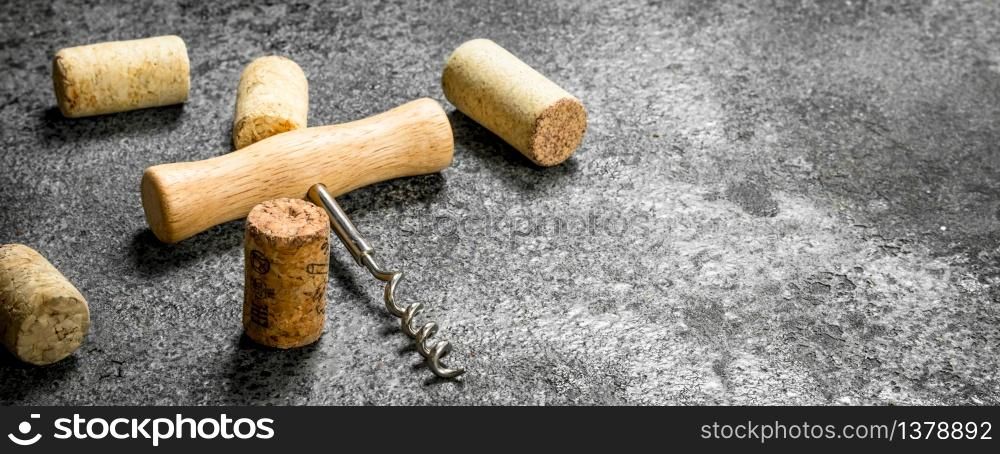 Corkscrew with wine corks. On a rustic background.. Corkscrew with wine corks.