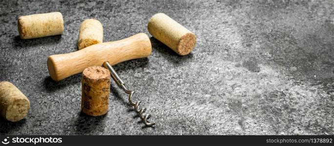 Corkscrew with wine corks. On a rustic background.. Corkscrew with wine corks.