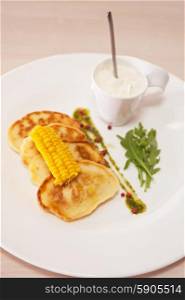 corn pancakes. corn pancakes with cream at plate