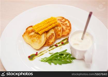 corn pancakes. corn pancakes with cream at plate