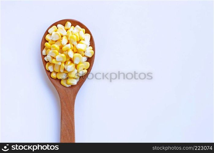 Corn seeds on wooden spoon, white background