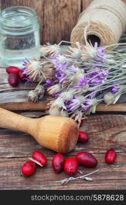 Cornel berries with herbaceous medicinal shrub. scattered medicinal Cornel berries and bowl of seeds of Heather on wooden table