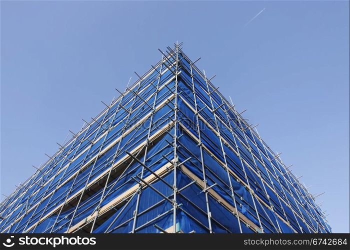 corner of blue scaffolding and blue sky with jet stream