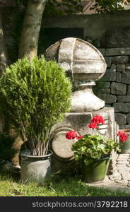 Corner of old garden with stonework, plants and flowers