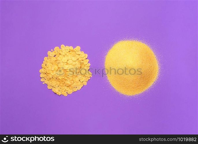 Cornmeal and corn flakes piles on purple background. Nutritious cooking ingredients. Above view of organic corn products. Minimal image of corn flour