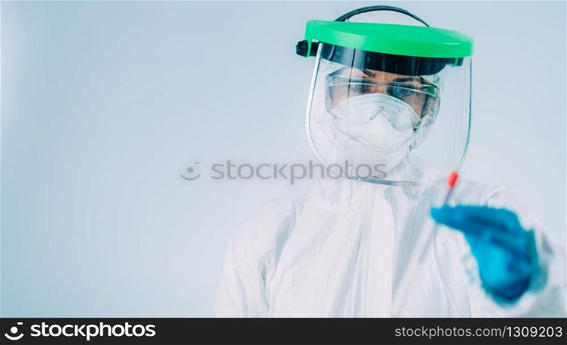 Corona virus test - Health worker in white hazmat protective suite with swab sample for PCR DNA testing . Corona virus test - Medical worker in white hazmat protective suite with swab sample for PCR DNA testing