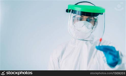 Corona virus test - Health worker in white hazmat protective suite with swab sample for PCR DNA testing . Corona virus test - Medical worker in white hazmat protective suite with swab sample for PCR DNA testing