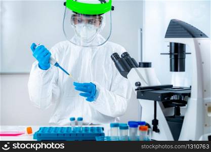 Corona Virus Vaccine Research, Scientist Working in the Institute Laboratory, Holding a micro pipette. Corona Virus Vaccine Research in the Laboratory