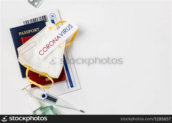 Coronavirus and travel concept. Passports, airplane tickets, sanitizer, thermometer and medical mask flat lay. Border control and quarantine of tourists infected with coronavirus. Flight cancellation coronavirus pandemic. Coronavirus Covid-19