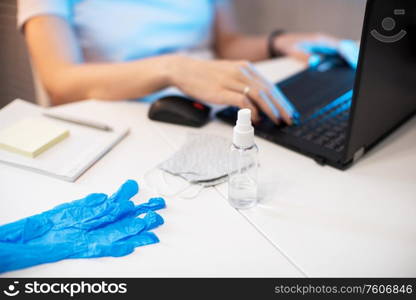 Coronavirus concept. Woman in quarantine for coronavirus covid-19 working from home. Protective mask and Sanitizer spray on the working place. working from home