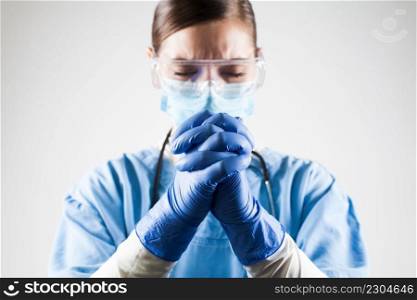 Coronavirus COVID-19 deadly virus disease taking many victims,global pandemic infected and dead patients,female doctor praying with hands clasped together gesture,hope faith belief salvation concept