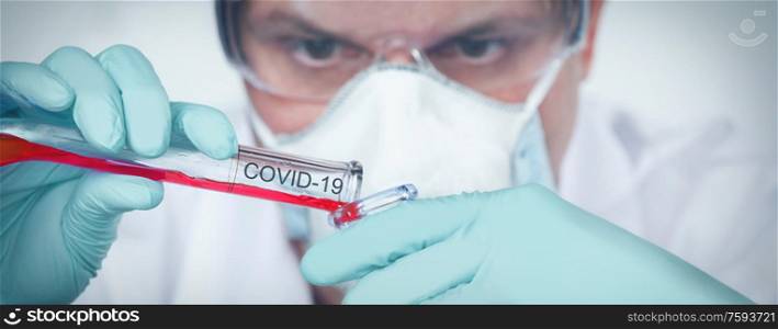 Coronavirus covid 19 infected blood sample in sample tube in hand of scientist with biohazard protection clothing in corona virus covid 19 research laboratory, coronavirus covid 19 vaccine research concept. Coronavirus covid 19 research