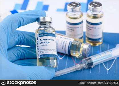 Coronavirus COVID-19 vaccine vial and injection syringe in scientist hands concept. Research for new novel corona virus vaccination immunization drug.