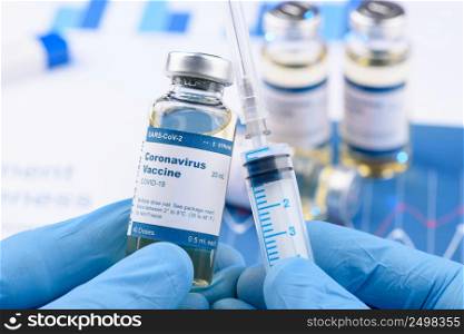Coronavirus COVID-19 vaccine vial and injection syringe in scientist hands concept. Research for new novel corona virus immunization drug.
