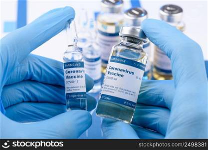 Coronavirus COVID-19 vaccine vials in scientist hands concept. Research for new novel corona virus immunization drug.