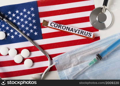 Coronavirus, nCoV concept. Top view of a protective breathing mask, stethoscope, syringe, pills on the flag of the United States. A new outbreak of the Chinese coronavirus. Coronavirus, nCoV concept. Top view of a protective breathing mask, stethoscope, syringe, pills on the flag of the United States.