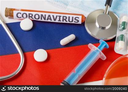 Coronavirus, nCoV concept. Top view of a protective breathing mask, stethoscope, syringe, pills on the flag of Russia. A new outbreak of the Chinese coronavirus. Coronavirus, nCoV concept. Top view of a protective breathing mask, stethoscope, syringe, pills on the flag of Russia.