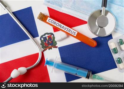 Coronavirus, nCoV concept. Top view of a protective breathing mask, stethoscope, syringe, pills on the flag of the Dominicana. A new outbreak of the Chinese coronavirus. Coronavirus, nCoV concept. Top view of a protective breathing mask, stethoscope, syringe, pills on the flag of the Dominicana.