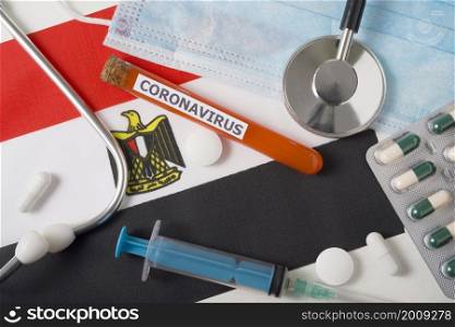 Coronavirus, nCoV concept. Top view protective breathing mask, stethoscope, syringe, pills on the flag of Egypt. A new outbreak of the Chinese coronavirus. Coronavirus, nCoV concept. Top view protective breathing mask, stethoscope, syringe, pills on the flag of Egypt.