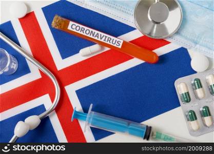 Coronavirus, nCoV concept. Top view protective breathing mask, stethoscope, syringe, pills on the flag of Iceland. A new outbreak of the Chinese coronavirus. Coronavirus, nCoV concept. Top view protective breathing mask, stethoscope, syringe, pills on the flag of Iceland.