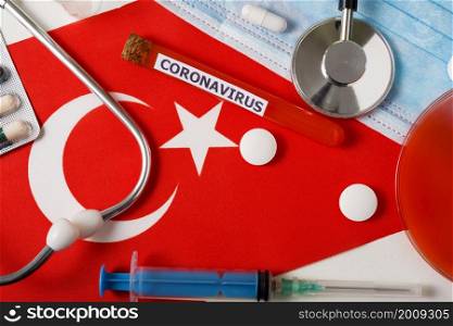 Coronavirus, nCoV concept. Top view protective breathing mask, stethoscope, syringe, pills on the flag of Turkey. A new outbreak of the Chinese coronavirus. Coronavirus, nCoV concept. Top view protective breathing mask, stethoscope, syringe, pills on the flag of Turkey.