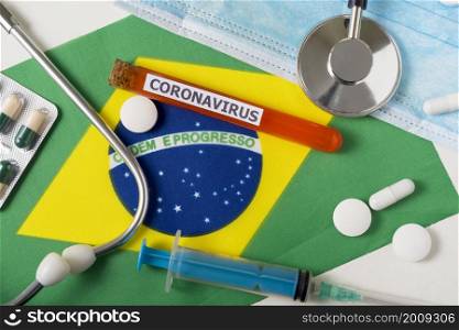 Coronavirus, nCoV concept. Top view protective breathing mask, stethoscope, syringe, pills on the flag of Brazil. A new outbreak of the Chinese coronavirus. Coronavirus, nCoV concept. Top view protective breathing mask, stethoscope, syringe, pills on the flag of Brazil.