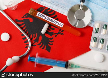Coronavirus, nCoV concept. Top view protective breathing mask, stethoscope, syringe, pills on the flag of Albania. A new outbreak of the Chinese coronavirus. Coronavirus, nCoV concept. Top view protective breathing mask, stethoscope, syringe, pills on the flag of Albania.