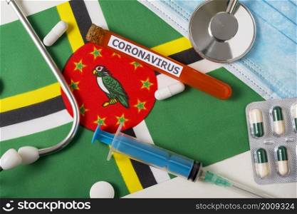 Coronavirus, nCoV concept. Top view protective breathing mask, stethoscope, syringe, pills on the flag of Dominica. A new outbreak of the Chinese coronavirus. Coronavirus, nCoV concept. Top view protective breathing mask, stethoscope, syringe, pills on the flag of Dominica.