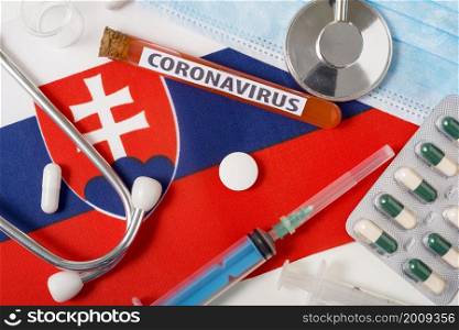 Coronavirus, nCoV concept. Top view protective breathing mask, stethoscope, syringe, tablets on the flag of Slovakia. A new outbreak of the Chinese coronavirus. Coronavirus, nCoV concept. Top view protective breathing mask, stethoscope, syringe, tablets on the flag of Slovakia.