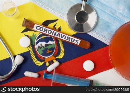 Coronavirus, nCoV concept. Top view protective breathing mask, stethoscope, syringe, tablets on the flag of Ecuador. A new outbreak of the Chinese coronavirus. Coronavirus, nCoV concept. Top view protective breathing mask, stethoscope, syringe, tablets on the flag of Ecuador.