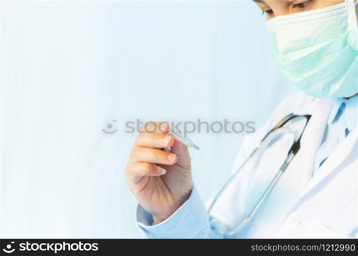 Coronavirus stop infection. young female doctor wearing mask with thermometer and stethoscope against infectious diseases and flu. Healthcare, medical education, emergency medical service, surgery concept