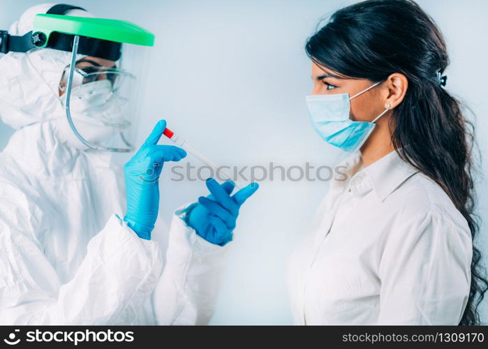 Coronavirus test. Medical worker in protective suite taking a swab for corona virus test, potentially infected young woman