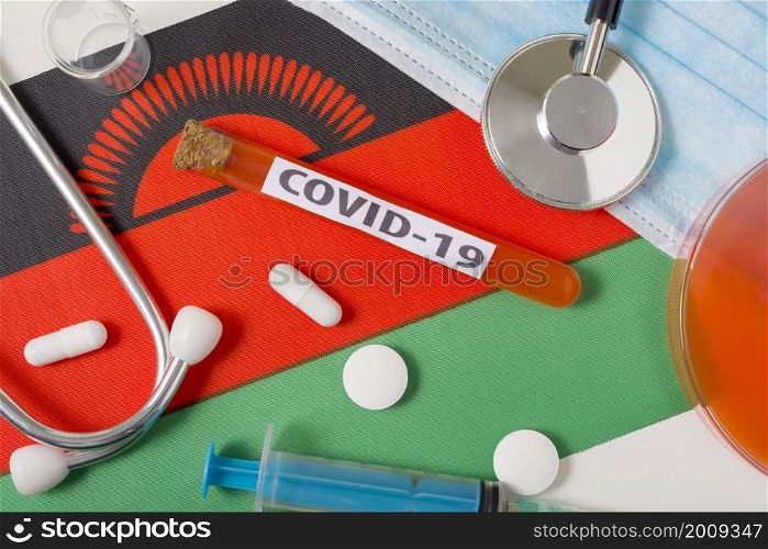 Coronavirus, the concept COVid-19. A protective breathing mask, stethoscope, syringe, and tablets on the flag of Malawi are visible from above . A new outbreak of the Chinese coronavirus. Coronavirus, the concept COVid-19. A protective breathing mask, stethoscope, syringe, and tablets on the flag of Malawi are visible from above .