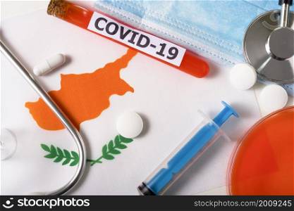 Coronavirus, the concept COVid-19. Top view of a protective breathing mask, stethoscope, syringe, pills on the flag of Cyprus. A new outbreak of the Chinese coronavirus. Coronavirus, the concept COVid-19. Top view of a protective breathing mask, stethoscope, syringe, pills on the flag of Cyprus.