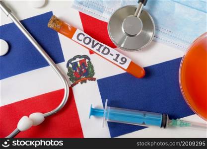 Coronavirus, the concept COVid-19. Top view of a protective breathing mask, stethoscope, syringe, pills on the flag of the Dominicana. A new outbreak of the Chinese coronavirus. Coronavirus, the concept COVid-19. Top view of a protective breathing mask, stethoscope, syringe, pills on the flag of the Dominicana.