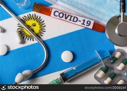 Coronavirus, the concept COVid-19. Top view protective breathing mask, stethoscope, syringe, pills on the flag of Argentina. A new outbreak of the Chinese coronavirus. Coronavirus, the concept COVid-19. Top view protective breathing mask, stethoscope, syringe, pills on the flag of Argentina.