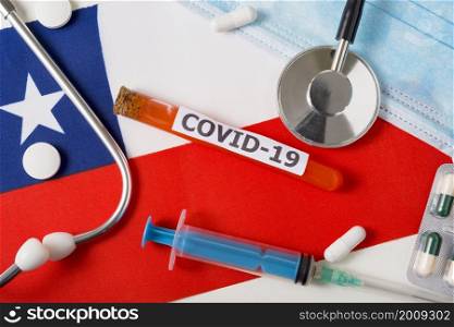 Coronavirus, the concept COVid-19. Top view protective breathing mask, stethoscope, syringe, pills on the flag of Chile. A new outbreak of the Chinese coronavirus. Coronavirus, the concept COVid-19. Top view protective breathing mask, stethoscope, syringe, pills on the flag of Chile.