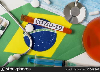 Coronavirus, the concept COVid-19. Top view protective breathing mask, stethoscope, syringe, pills on the flag of Brazil. A new outbreak of the Chinese coronavirus. Coronavirus, the concept COVid-19. Top view protective breathing mask, stethoscope, syringe, pills on the flag of Brazil.