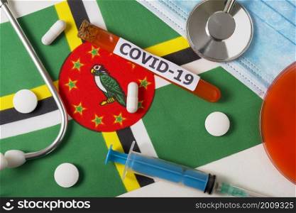 Coronavirus, the concept COVid-19. Top view protective breathing mask, stethoscope, syringe, pills on the flag of Dominica. A new outbreak of the Chinese coronavirus. Coronavirus, the concept COVid-19. Top view protective breathing mask, stethoscope, syringe, pills on the flag of Dominica.