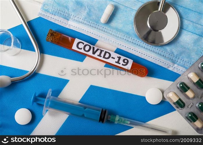 Coronavirus, the concept COVid-19. Top view protective breathing mask, stethoscope, syringe, pills on the flag of Scotland. A new outbreak of the Chinese coronavirus. Coronavirus, the concept COVid-19. Top view protective breathing mask, stethoscope, syringe, pills on the flag of Scotland.