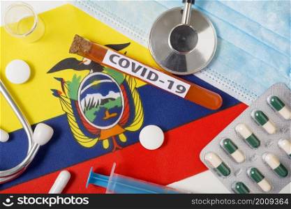 Coronavirus, the concept COVid-19. Top view protective breathing mask, stethoscope, syringe, tablets on the flag of Ecuador. A new outbreak of the Chinese coronavirus. Coronavirus, the concept COVid-19. Top view protective breathing mask, stethoscope, syringe, tablets on the flag of Ecuador.