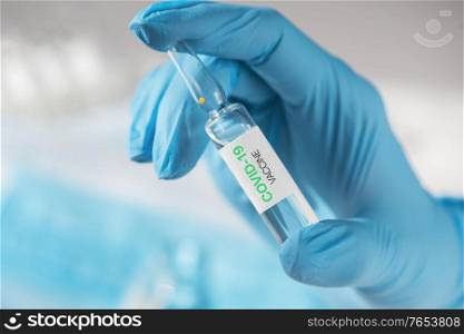 Coronavirus vaccine concept: covid-19 vaccine in hand with blue protective gloves.. Coronavirus vaccine concept