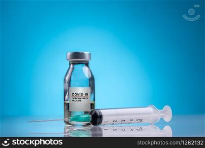 Coronavirus Vaccine / Corona virus Vaccine concept with Vial and Syringe on blue background. Coronavirus Vaccine Concept