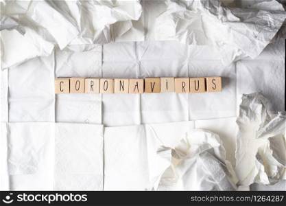 Coronavirus written on wooden cubes surrounded with tissues, NCOV concept background. Coronavirus written on wooden cubes surrounded with tissues, NCOV concept