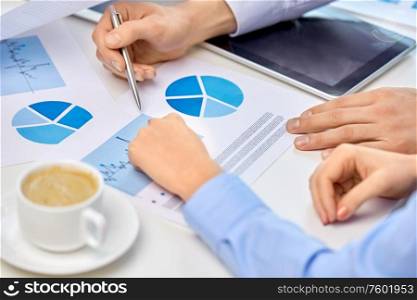 corporate and people concept - close up of business team hands with pens and charts at office. business team hands with pens and charts at office