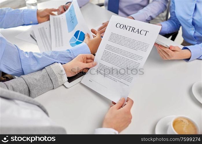 corporate and people concept - close up of business team with charts and contract at office. close up of business team with charts and contract