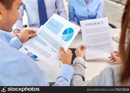 corporate and people concept - close up of business team with charts and contract at office. close up of business team with charts and contract