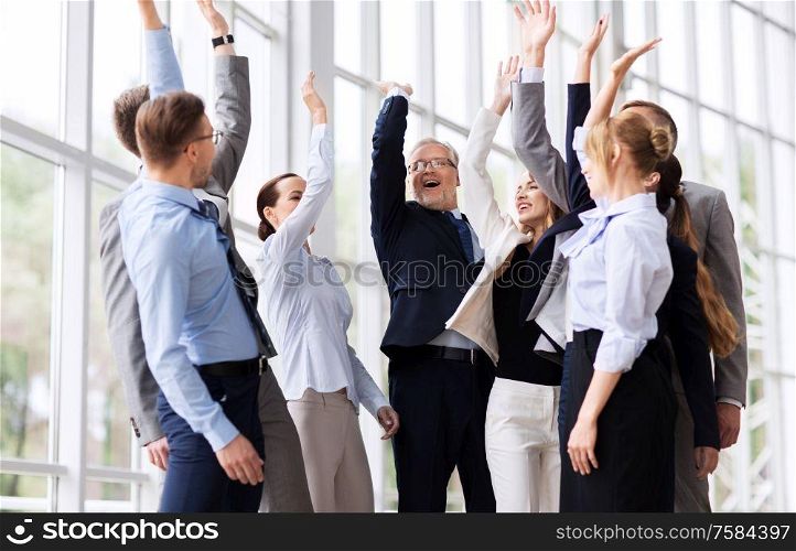 corporate and teamwork concept - happy business team making high five or celebrating success at office. business people celebrating success at office